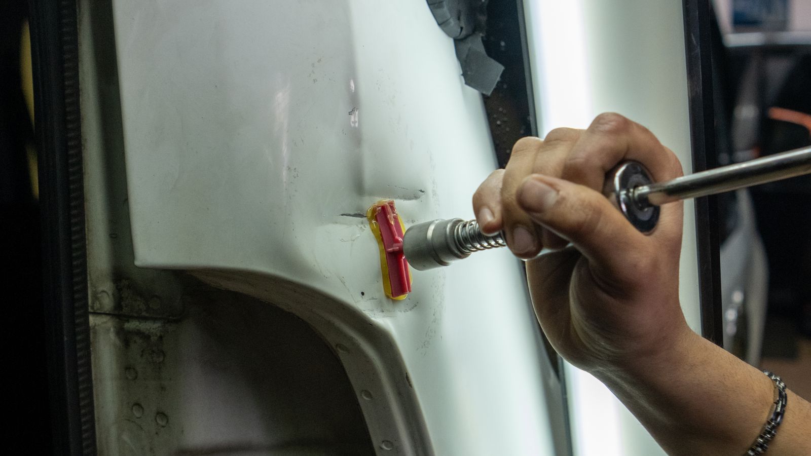 Dent being worked out of a vehicle panel